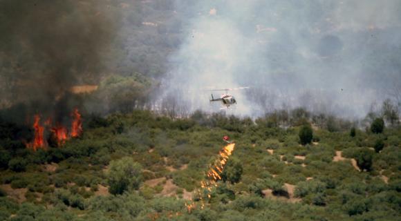 Helichopter dropping fire in brush land