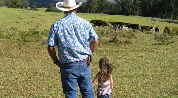 Rancher and daughter looking at cattle