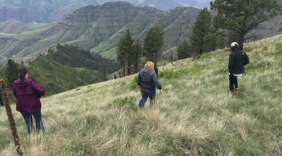 Three women hiking down a steep slop in Hells Canyon