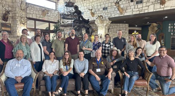 a group of RP members sitting together in a room with a lot of taxidermy 